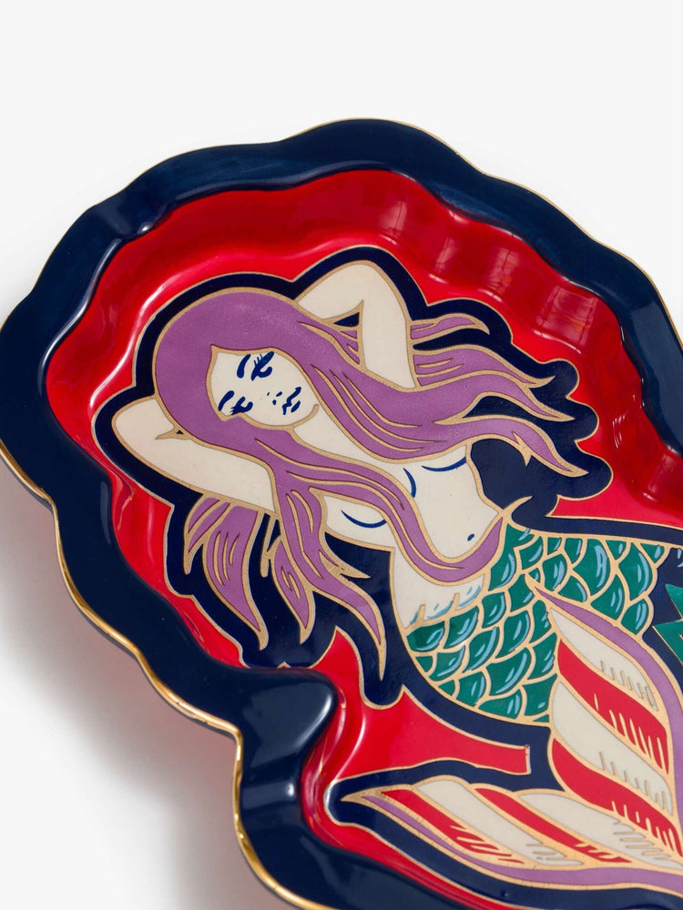 Flat close up image of a ceramic tray, featuring a colorful mermaid.