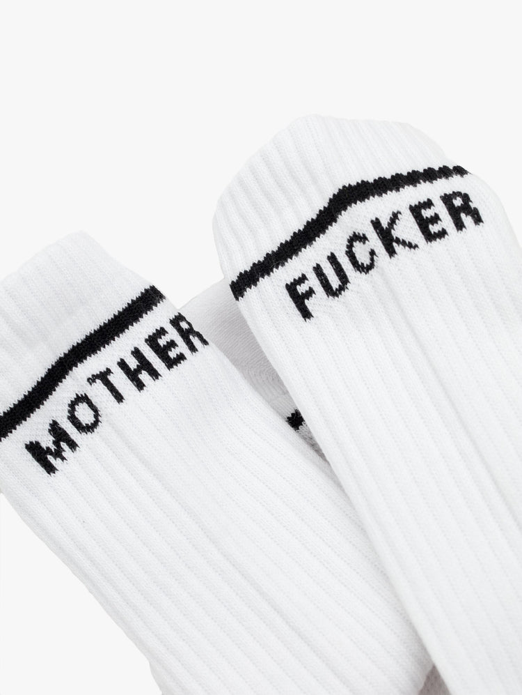 Close up view of a womens pair of white socks with the words "MOTHER" and "FUCKER".