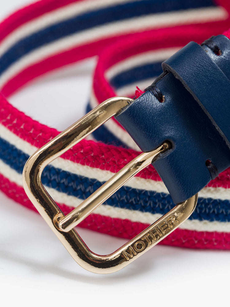 Close up view of a belt in shiny gold-colored buckle and vintage vibe in red, white and navy stripes.