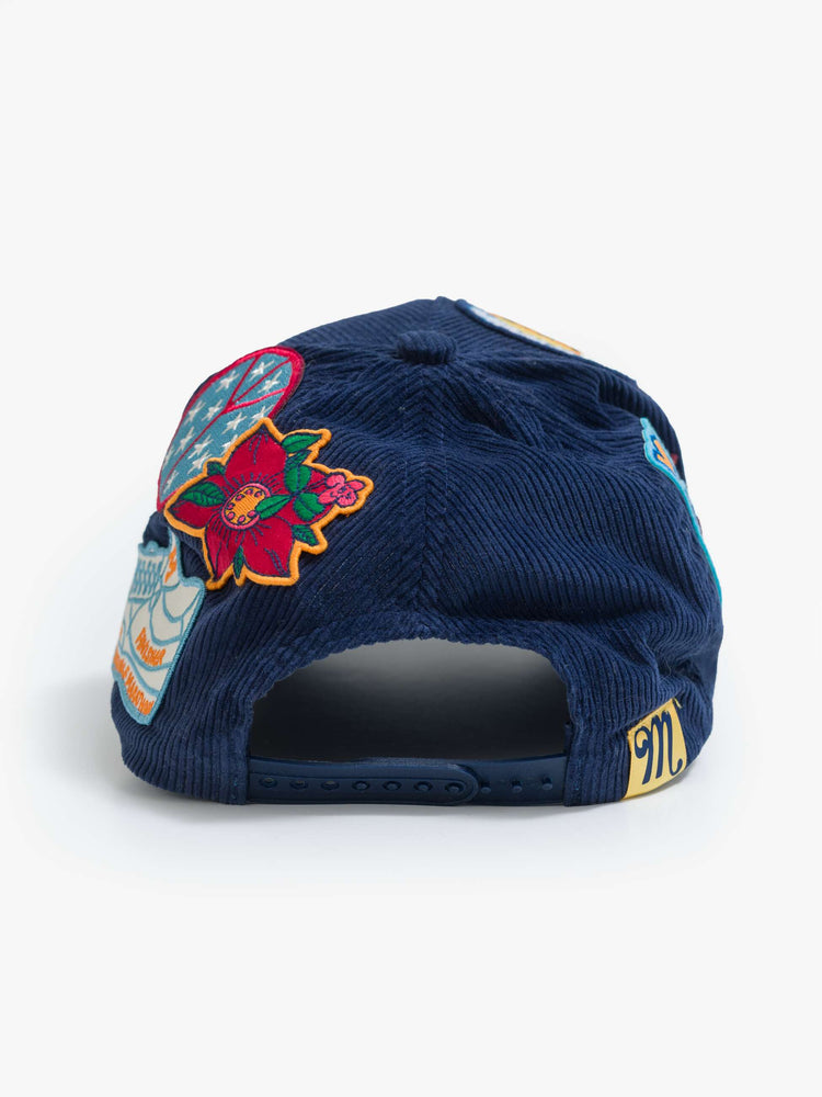 Flat view of in a navy corduroy hat with MOTHER's name on the front and colorful patches throughout.