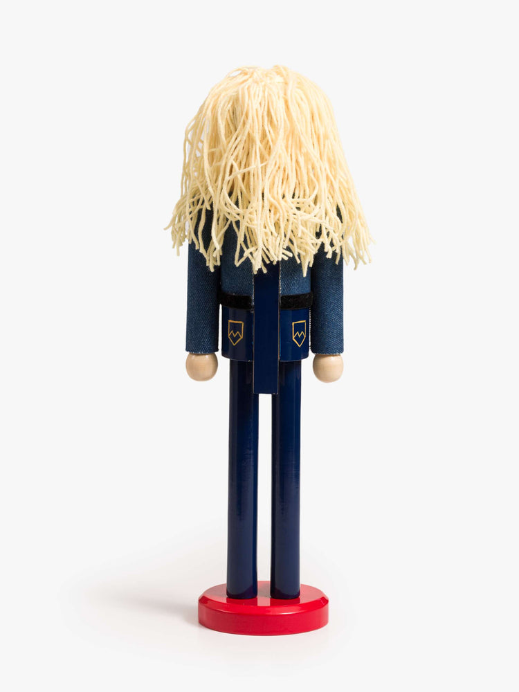 Back view of a traditional nutcracker a 70s-inspired twist with a Canadian tuxedo, turquoise-detailed belt, blonde braids, pink bows and a MOTHER heart charm.