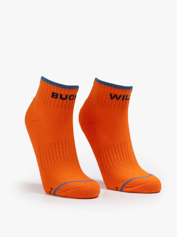 Front view of a orange with blue text ankle-length tube socks with a subtle heads up from MOTHER. 