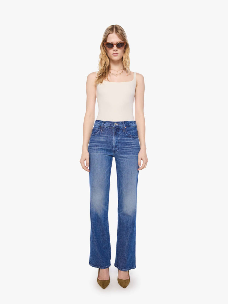 Front view of a petite woman in mid blue high-rise straight leg jean with a zip fly, long 30-inch inseam and a clean hem.