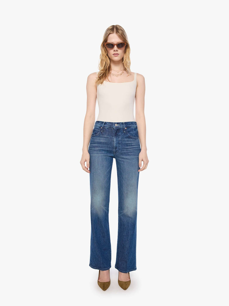 Front view of a petite woman in mid blue high-rise straight leg jean with a zip fly, long 30-inch inseam and a clean hem.