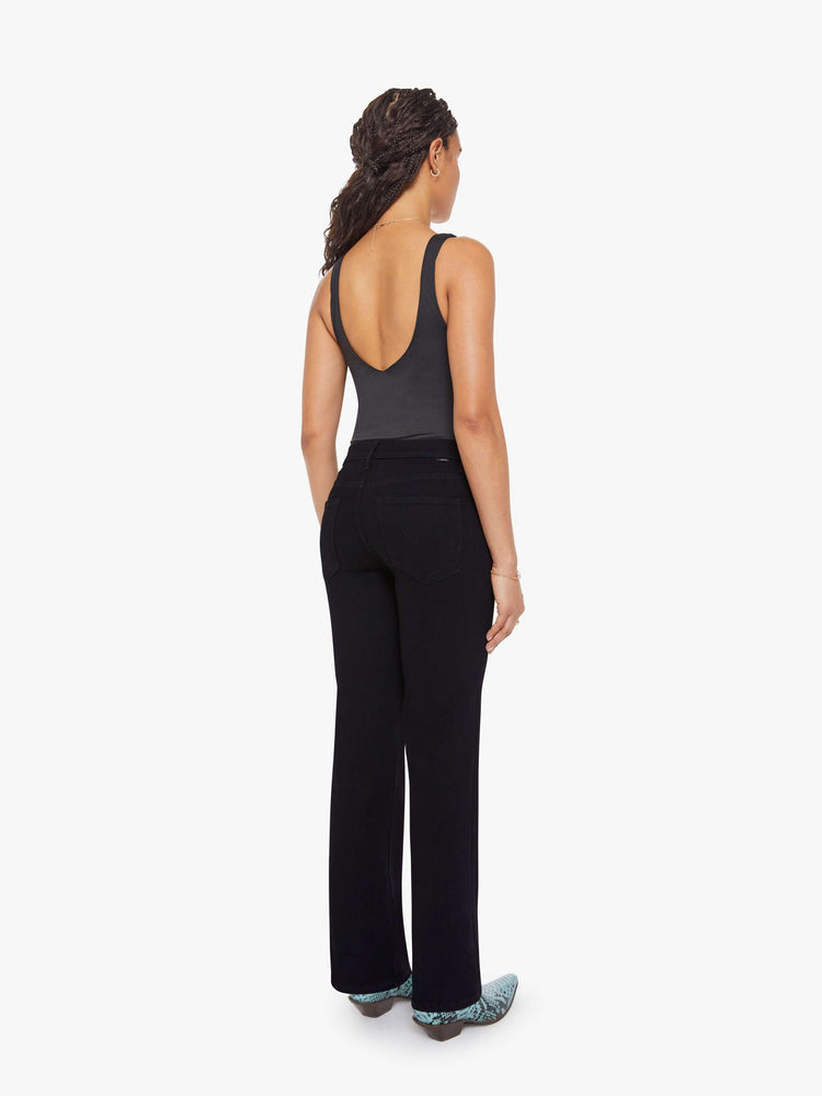 Back view of a woman in a black high-rise straight leg jean with a 30-inch inseam and a clean hem.