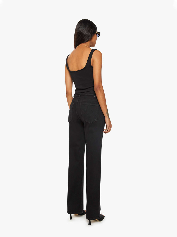 Back view of a woman in a black high-rise straight leg jean with a 30-inch inseam and a clean hem.