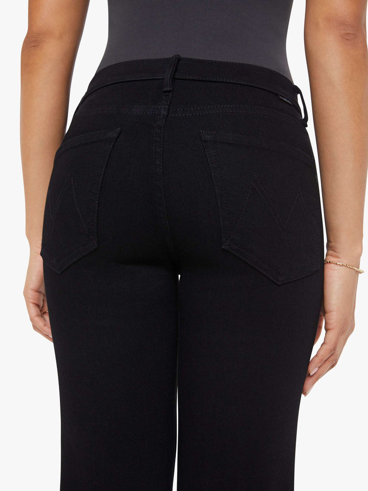 Close up view of a woman in a black high-rise straight leg jean with a 30-inch inseam and a clean hem.