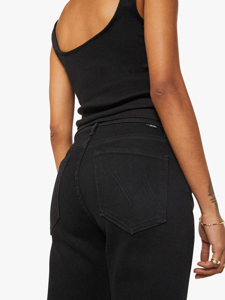 Close up view of a woman in a black high-rise straight leg jean with a 30-inch inseam and a clean hem.