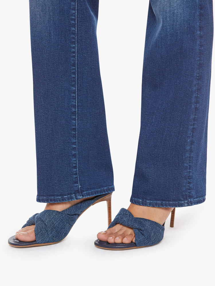 Hem view of a petite woman in a med blue high-rise straight leg jean with a zip fly, 31.25-inch inseam and a clean hem.