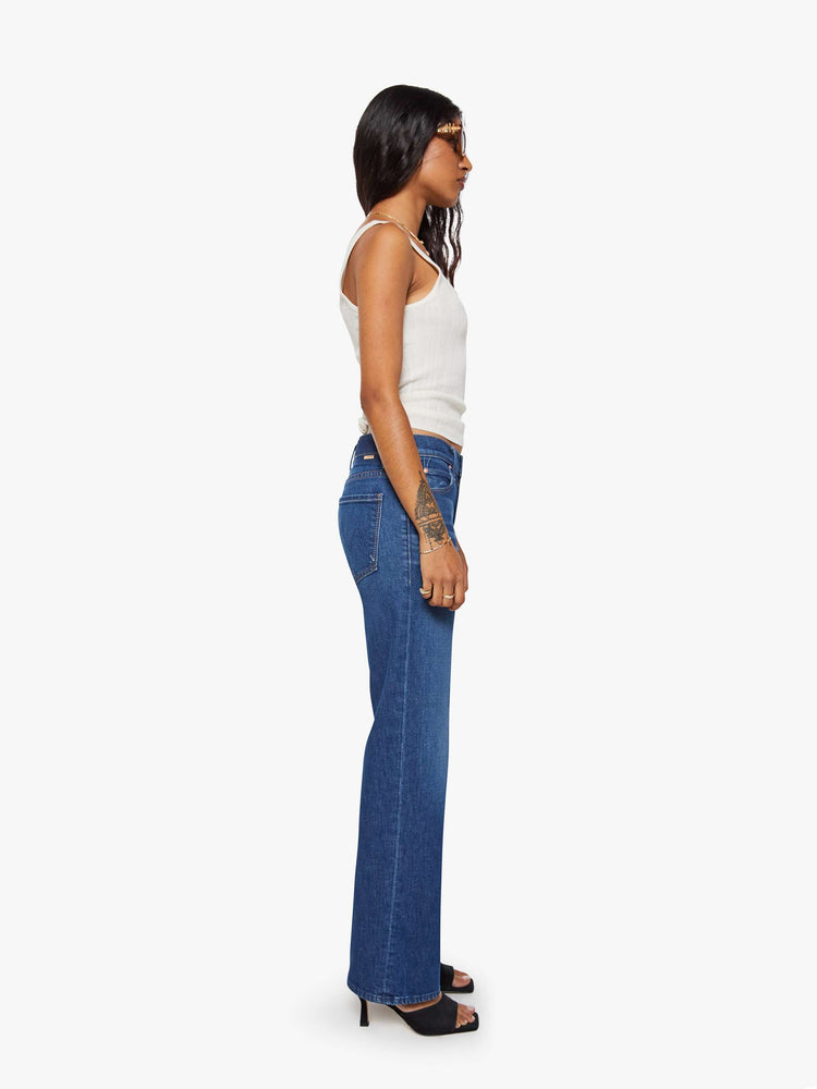 Side view of a petite woman in a high-rise straight leg jean with a zip fly, 29-inch inseam and a clean hem.