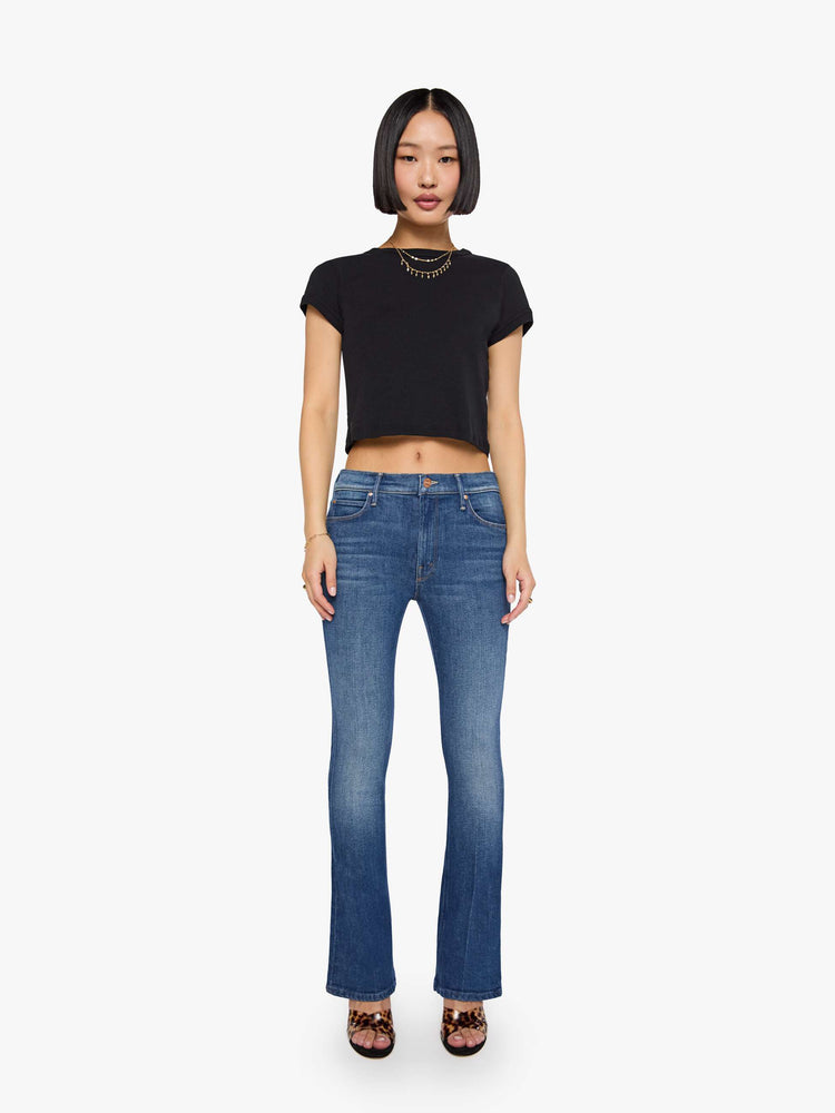 Front view of a woman med blue in a skinny flare with a mid rise, zip fly and a long 30-inch inseam with a clean hem.