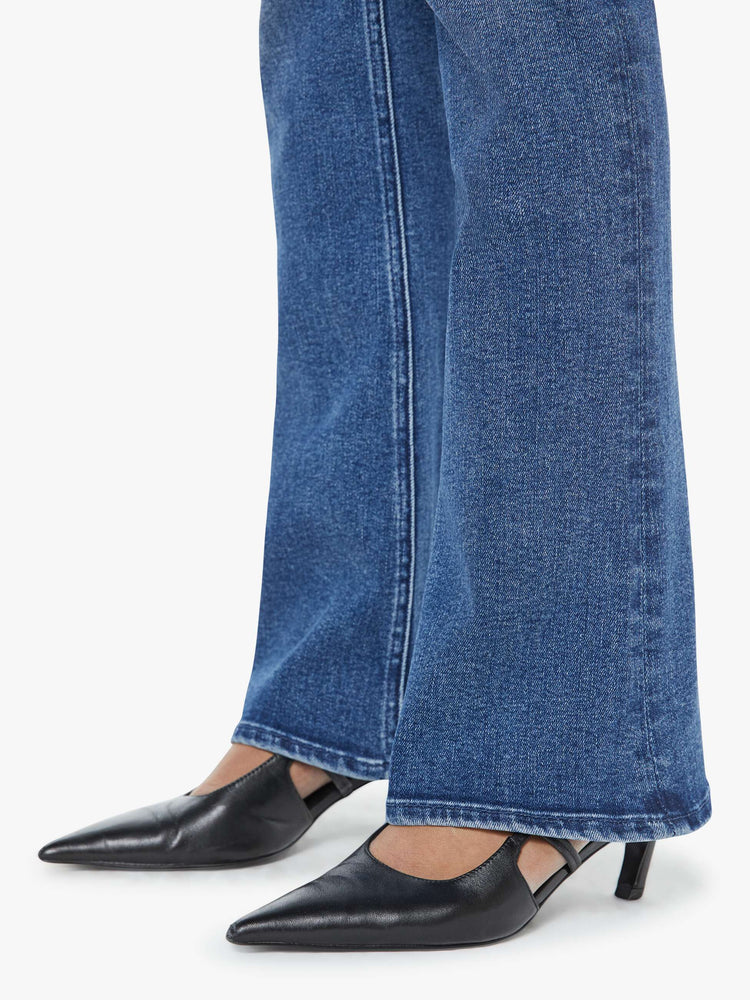 Hem view of a petite woman in a med blue  classic skinny flare with a mid rise, zip fly and a long 31-inch inseam with a clean hem. 