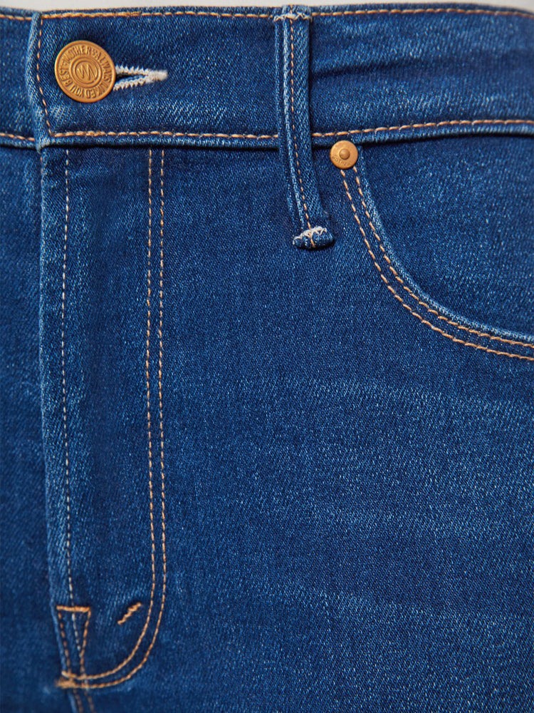Swatch view of a petite woman in a dark blue skinny flare with a mid rise, zip fly and a long 30-inch inseam with a clean hem.