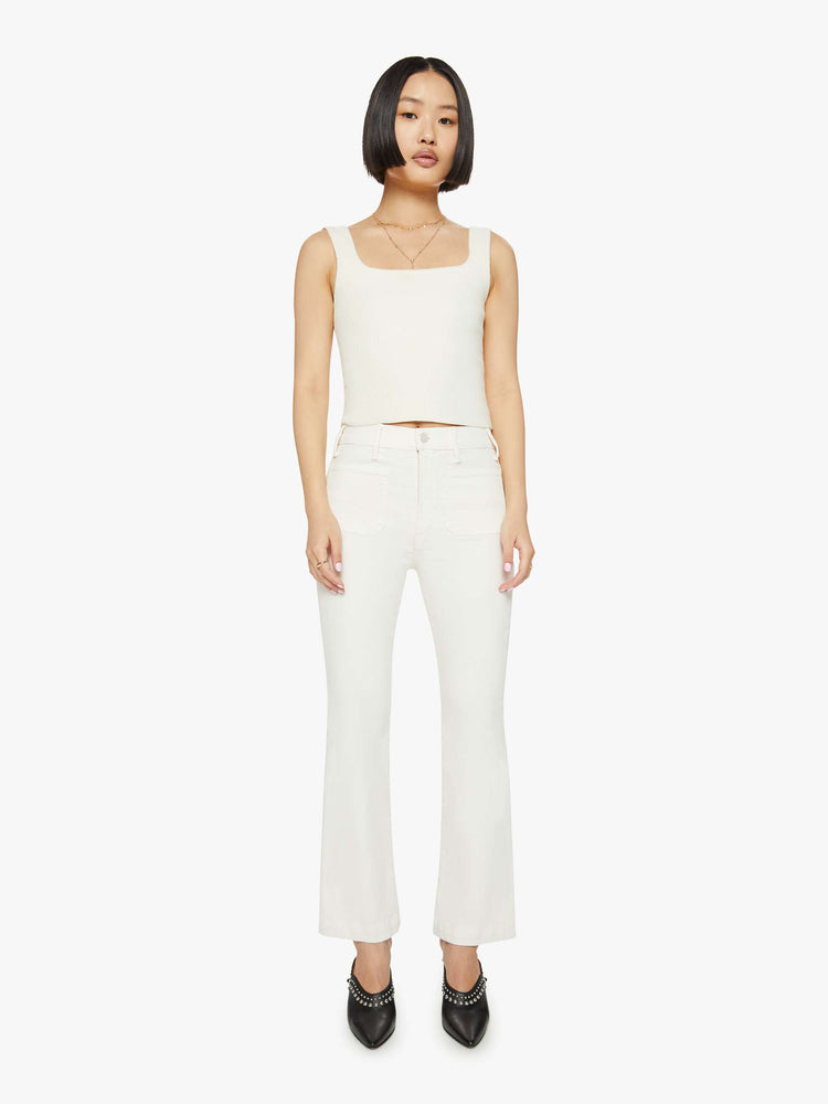 Front view of a woman off white high-rise bootcut has a cropped inseam, patch pockets and a clean hem.