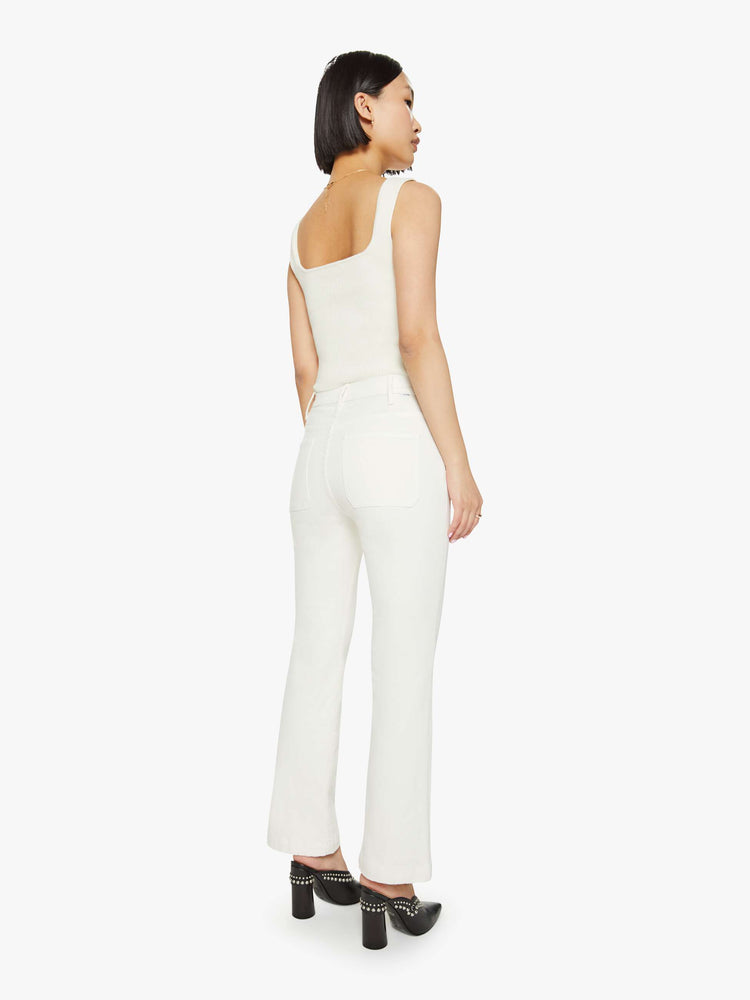 Back  view of a woman off white high-rise bootcut has a cropped inseam, patch pockets and a clean hem.