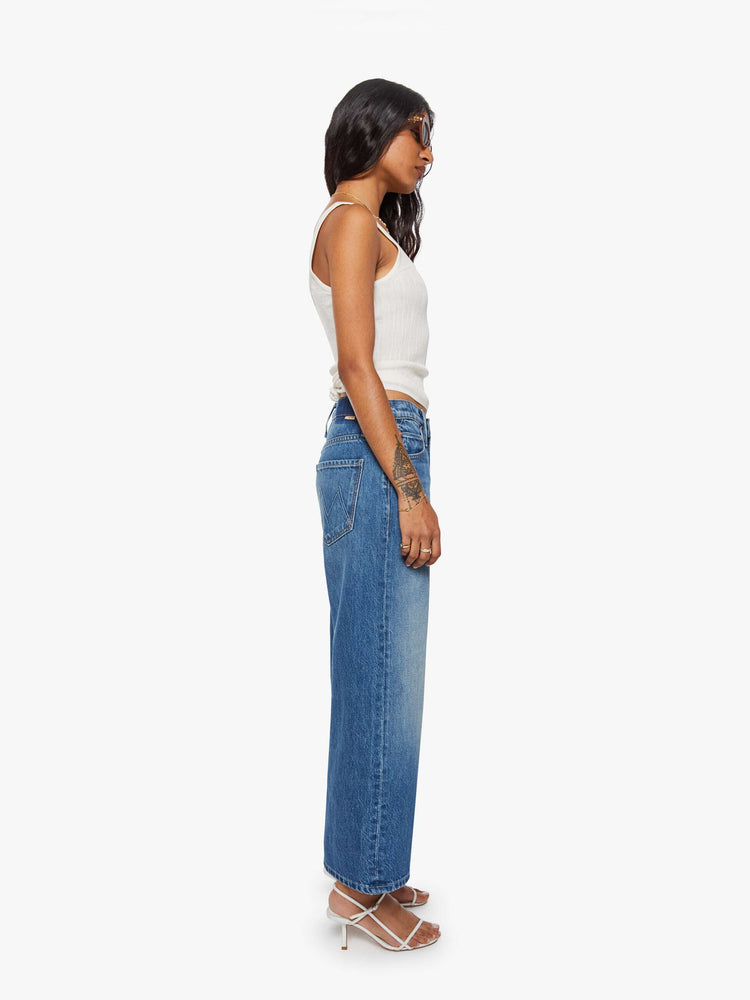 Side view of a woman in jeans designed to sit on the hips with a slouchy fit, a loose straight leg, button fly and a 26.25-inch inseam with a clean hem.