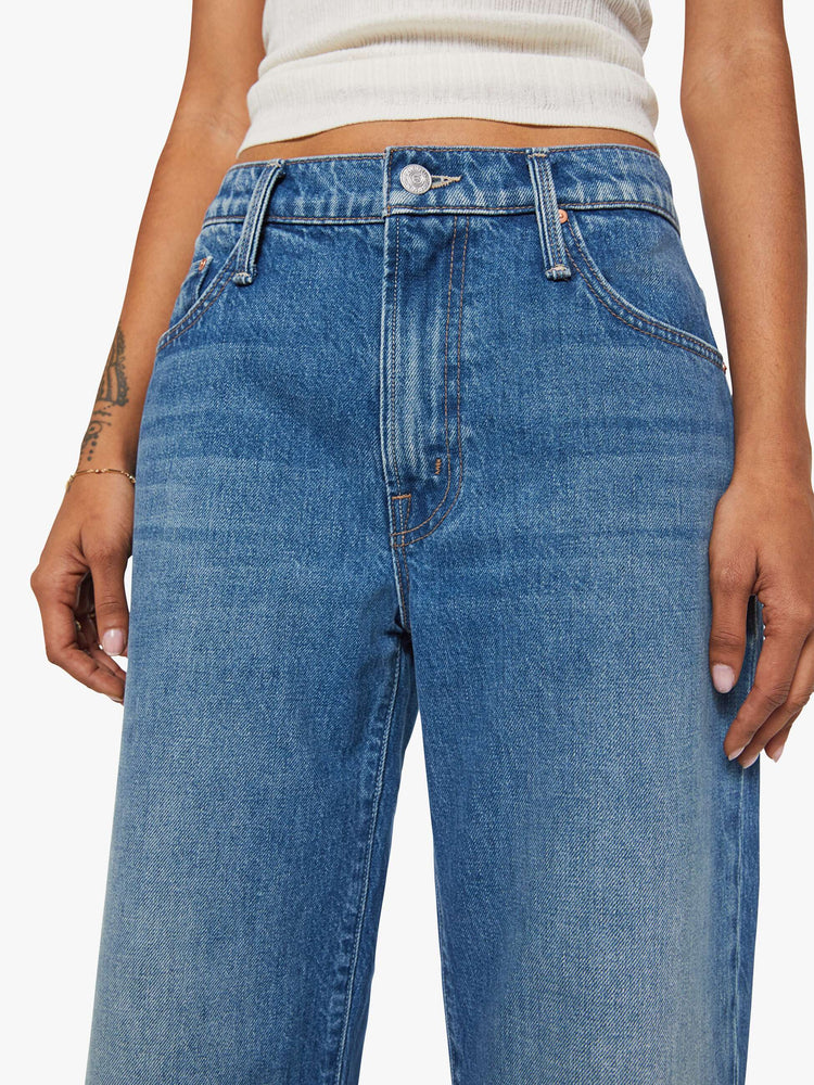 Close up view of a woman in jeans designed to sit on the hips with a slouchy fit, a loose straight leg, button fly and a 26.25-inch inseam with a clean hem.