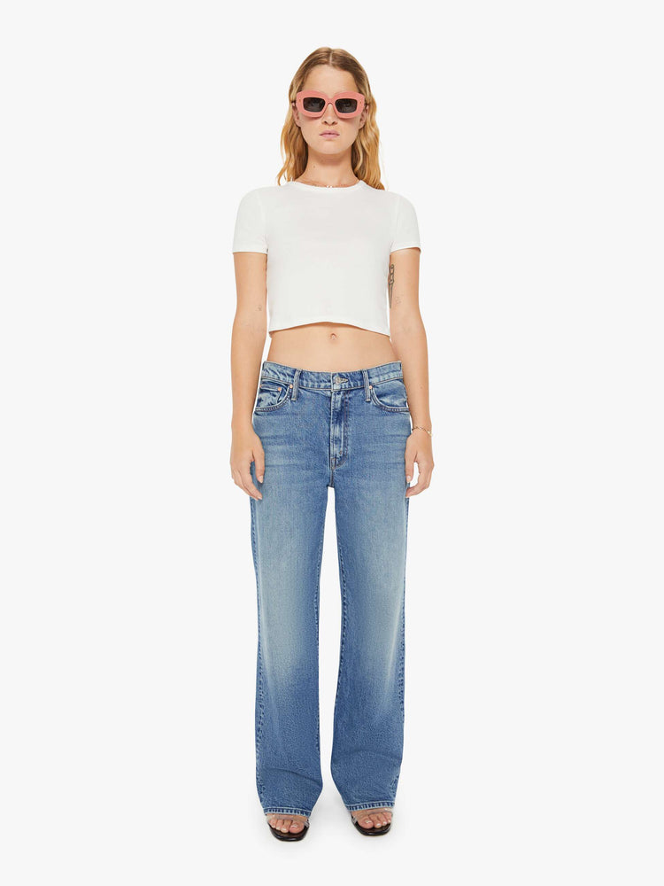 Front view of a womens medium blue wash jean featuring a relaxed mid rise, a wide leg, and clean hem.