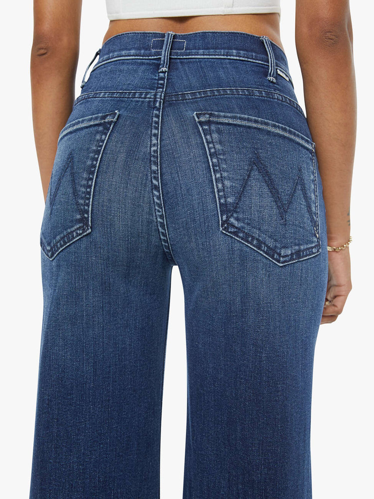 Back close up view of a petite woman in a dark blue  wide leg jeans have a high rise, zip fly, long 29-inch inseam and a clean hem.