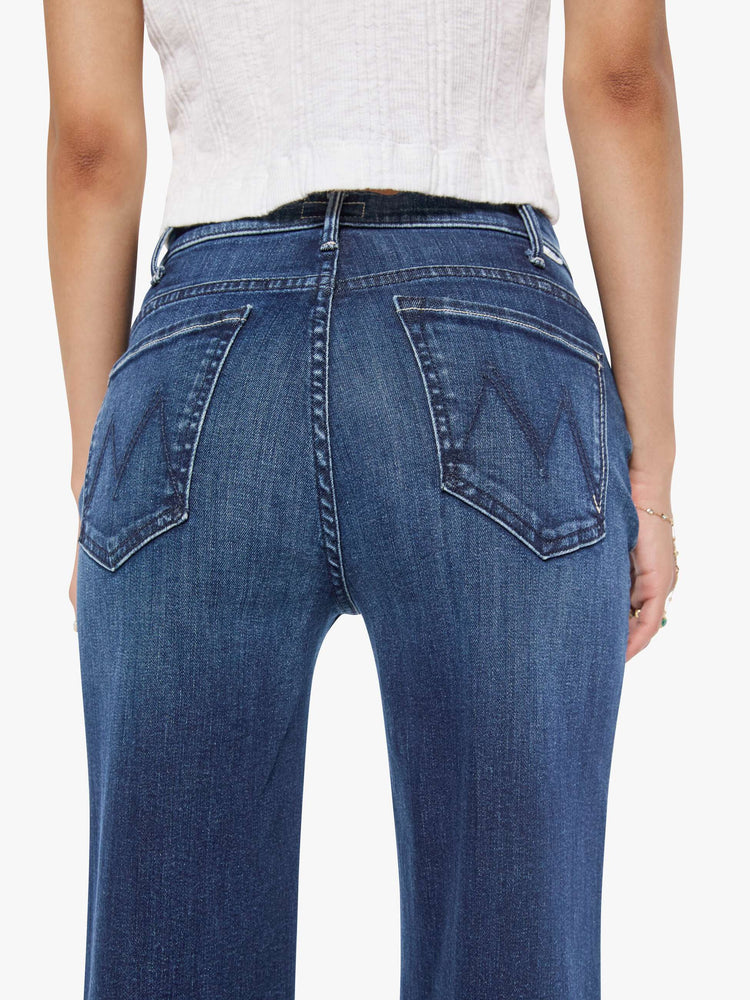 Back close up view of a petite woman in a dark blue  wide leg jeans have a high rise, zip fly, long 29-inch inseam and a clean hem.