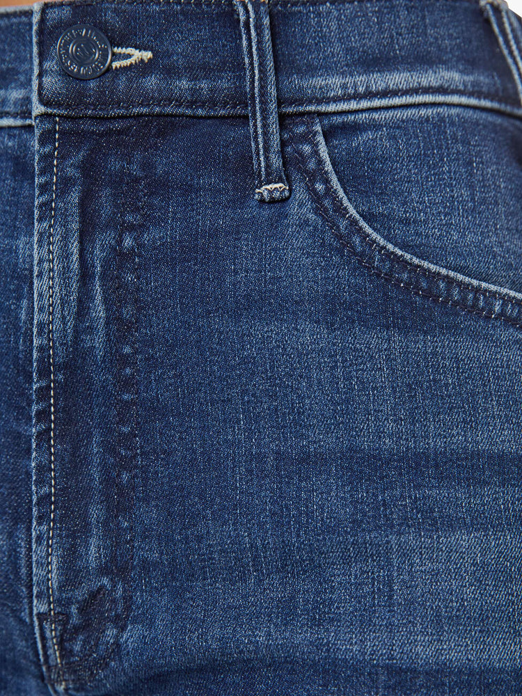 Close up view of a petite woman in a dark blue  wide leg jeans have a high rise, zip fly, long 29-inch inseam and a clean hem.