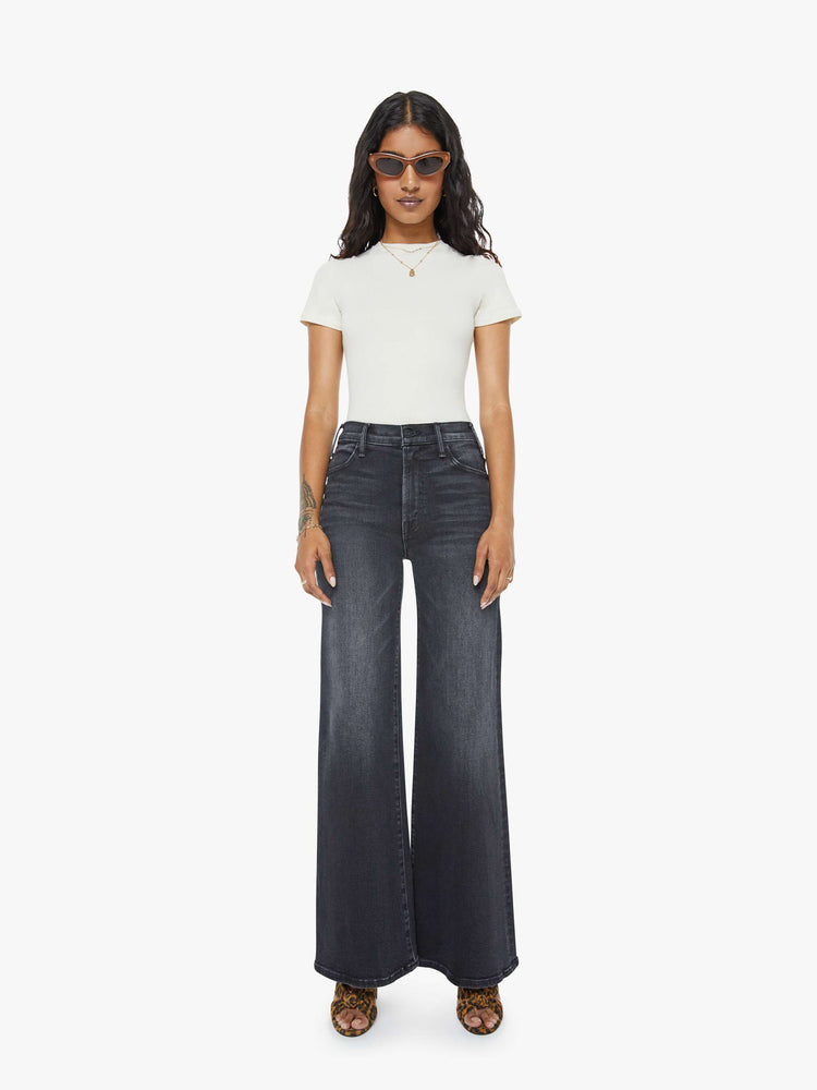 Front view of a petite woman in a black wash  wide leg jeans with a high rise, 30-inch inseam and a clean hem. 