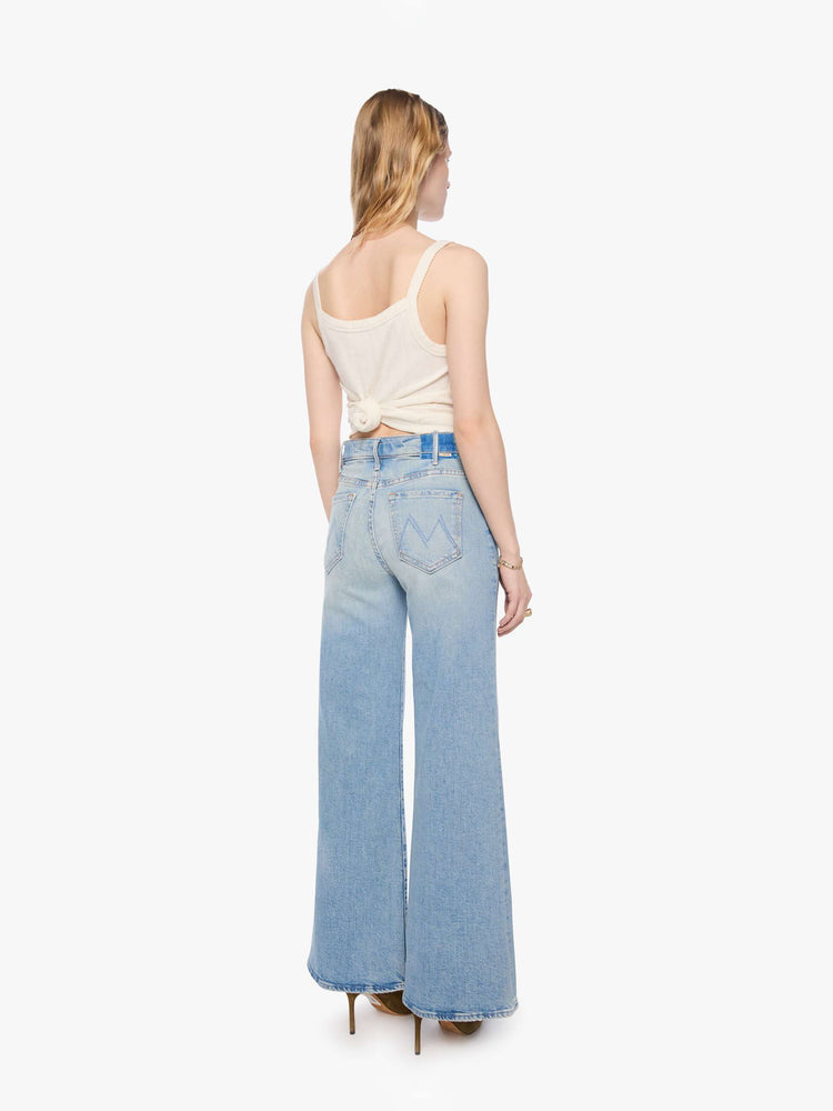 Back view of a petite woman in a light blue wide leg jeans with a high rise, zip fly, 32-inch inseam and a clean hem.