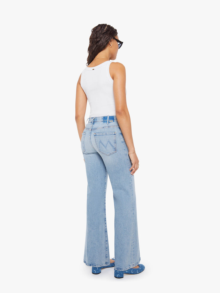 Back view of a petite woman in a light blue wide leg jeans with a high rise, zip fly, 32-inch inseam and a clean hem.