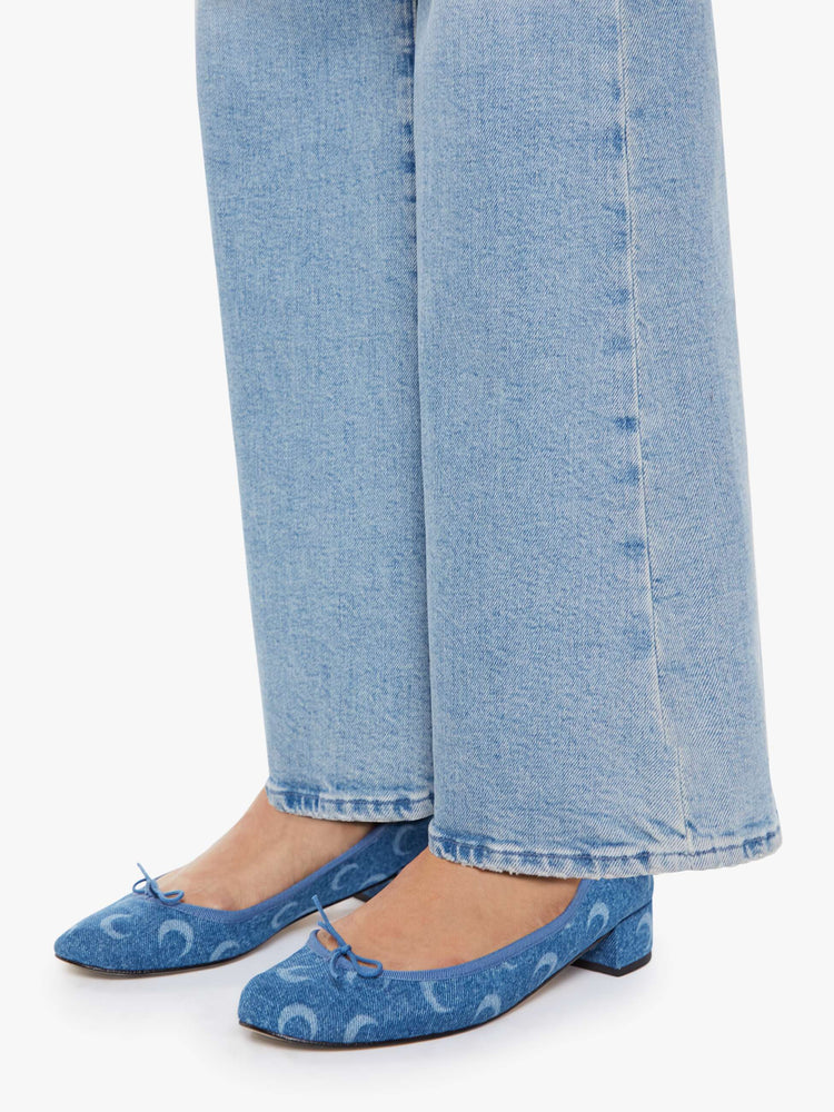 Hem view of a petite woman in a light blue wide leg jeans with a high rise, zip fly, 32-inch inseam and a clean hem.