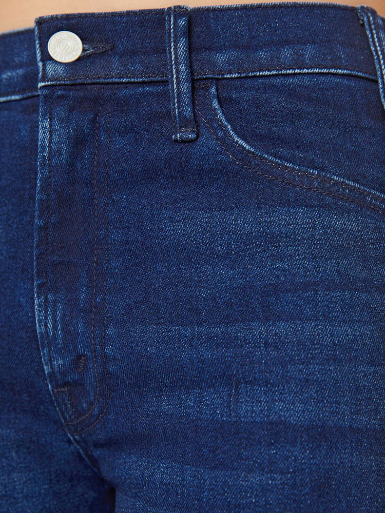 Swatch view of a petite woman in a high-rise bootcut has a long inseam and a clean hem in a dark blue wash.