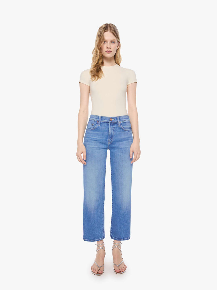 Front view of a petite woman in a mid-rise jeans with a wide straight leg, zip fly and clean ankle-length inseam.