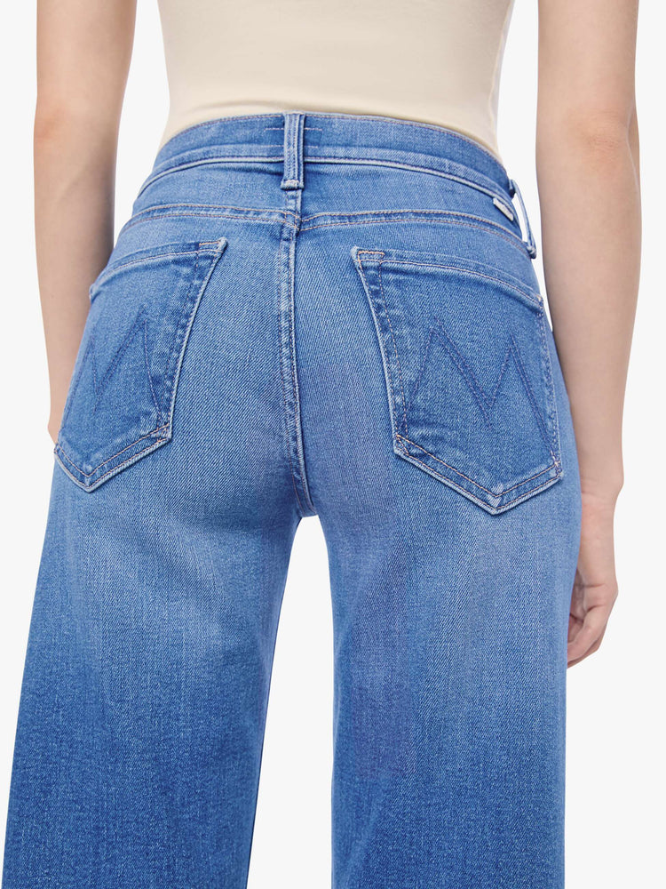 Back close up view of a petite woman in a mid-rise jeans with a wide straight leg, zip fly and clean ankle-length inseam.