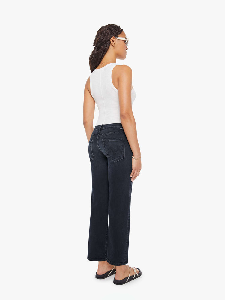 Back view of a petite woman in a dark denim mid-rise jean with a wide straight leg, zip fly and clean ankle-length inseam.