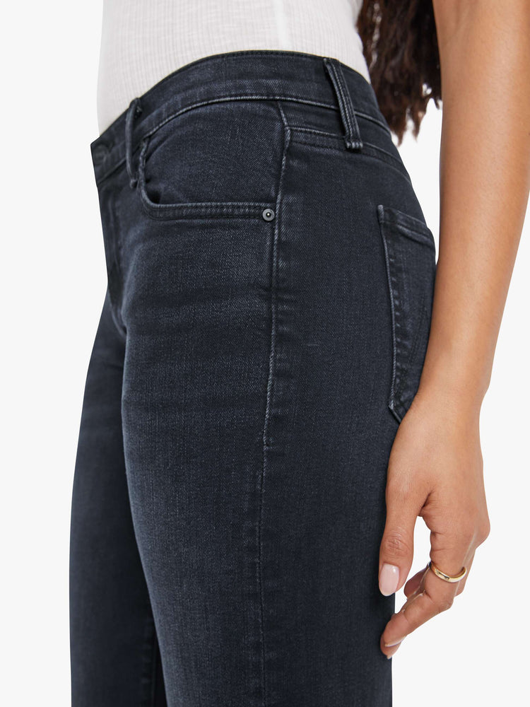 Close up view of a petite woman in a dark denim mid-rise jean with a wide straight leg, zip fly and clean ankle-length inseam.
