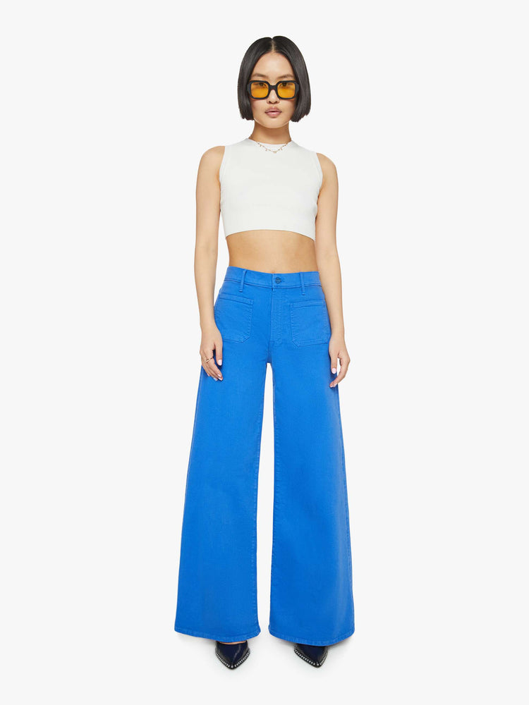 Front view of a woman in a bright sea blue wide leg pants with a high rise, patch pockets and a clean hem.
