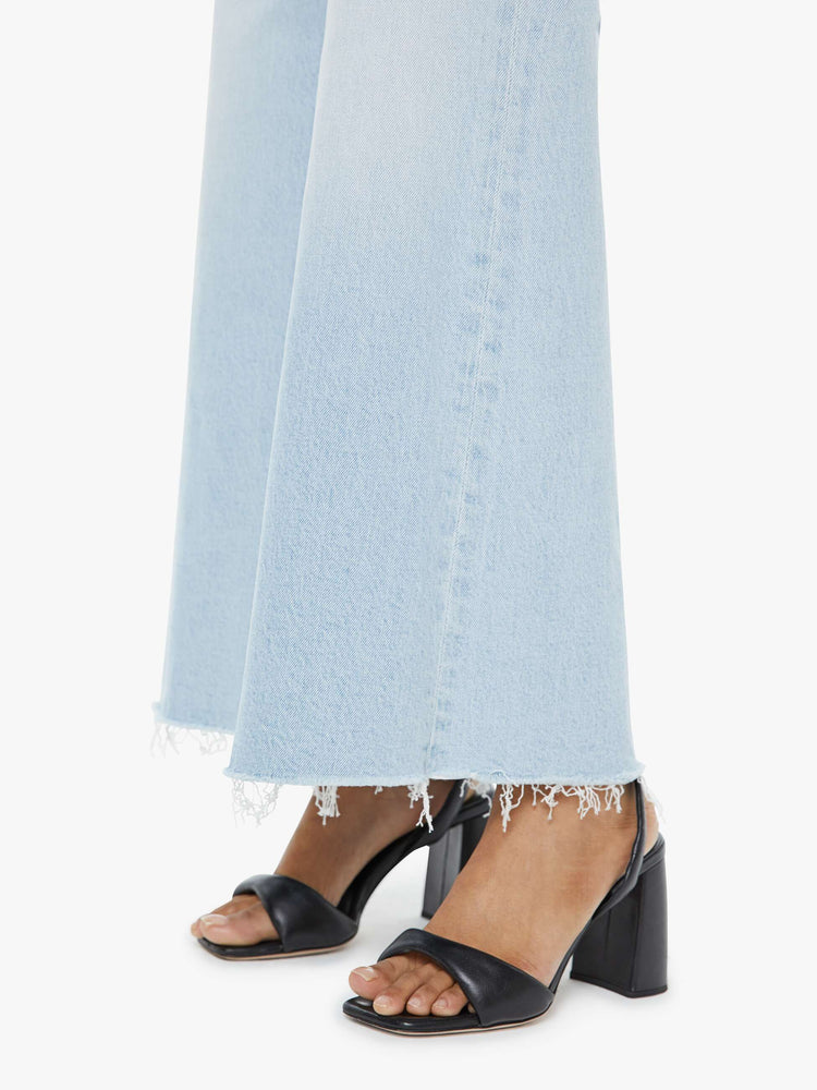 Close up view of a petite woman in a light blue  wide leg pants with a zip fly, high rise, 29-inch inseam and a frayed hem. 