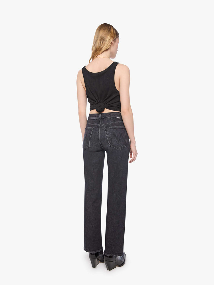 Back view of a petite woman in a washed black igh-rise jeans with a straight leg, zip fly and a 29-inch inseam with a clean hem.