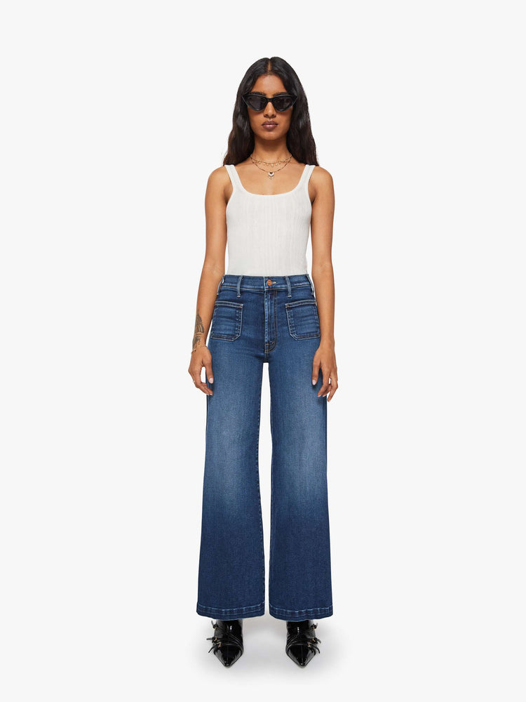 Front view of a woman in a dark blue wide leg jeans with a high rise, zip fly, patch pockets, 30-inch inseam and clean hem.