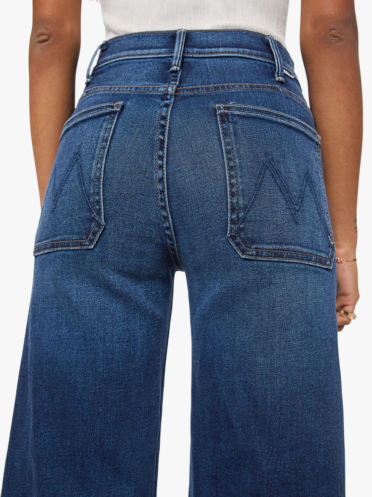 Close up view of a woman in a dark blue wide leg jeans with a high rise, zip fly, patch pockets, 30-inch inseam and clean hem.