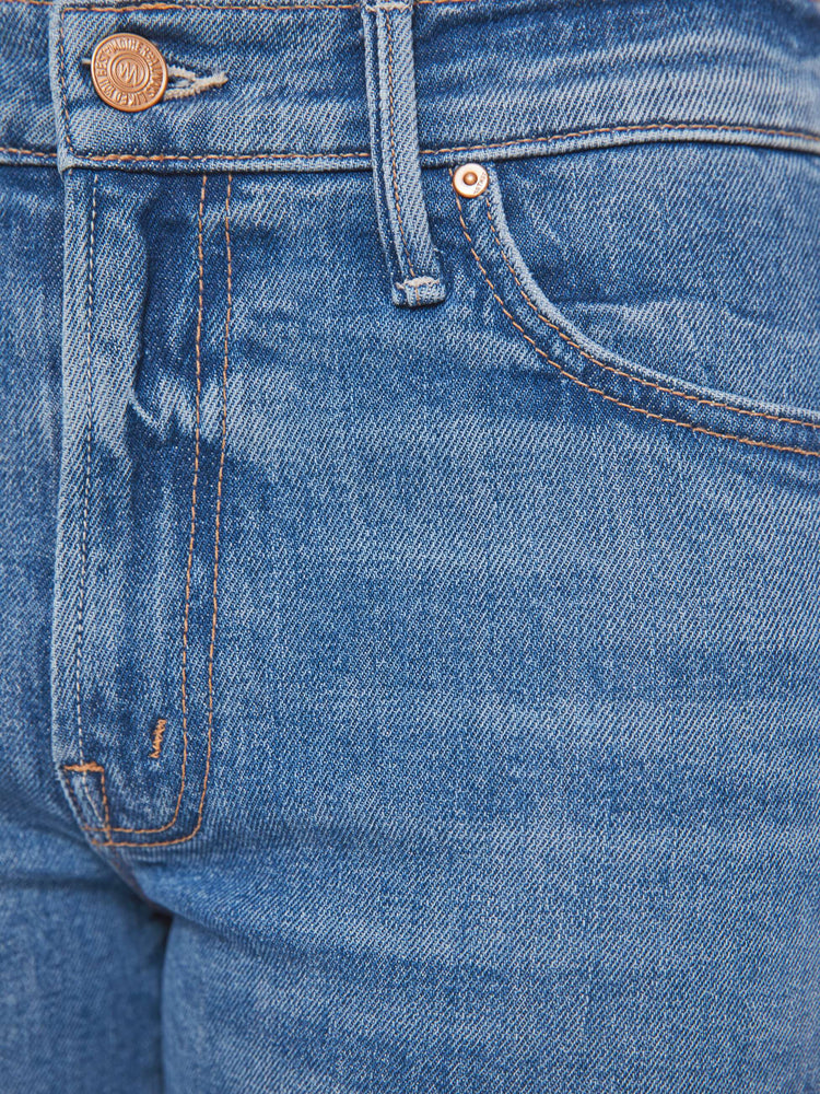 Swatch view of a petite woman in a mid blue bootcut jeans with a mid rise, zip fly and a long 29-inch inseam with a clean hem. 