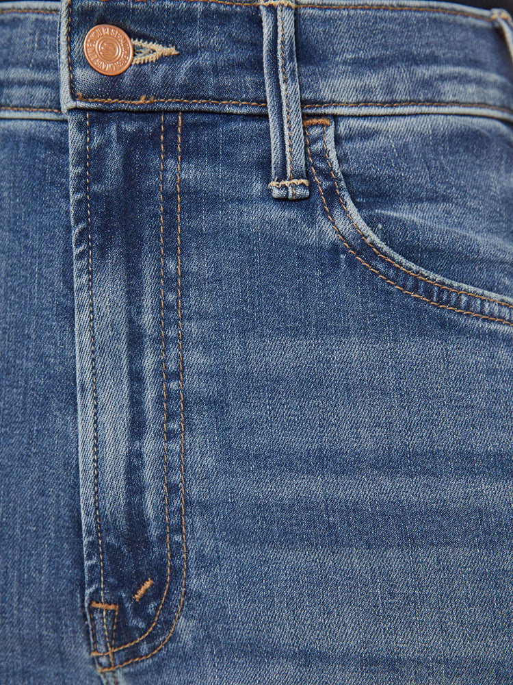 Swatch  view of a petite woman mid blue wash jean with a high-rise flare has an ankle-length inseam and a raw hem.