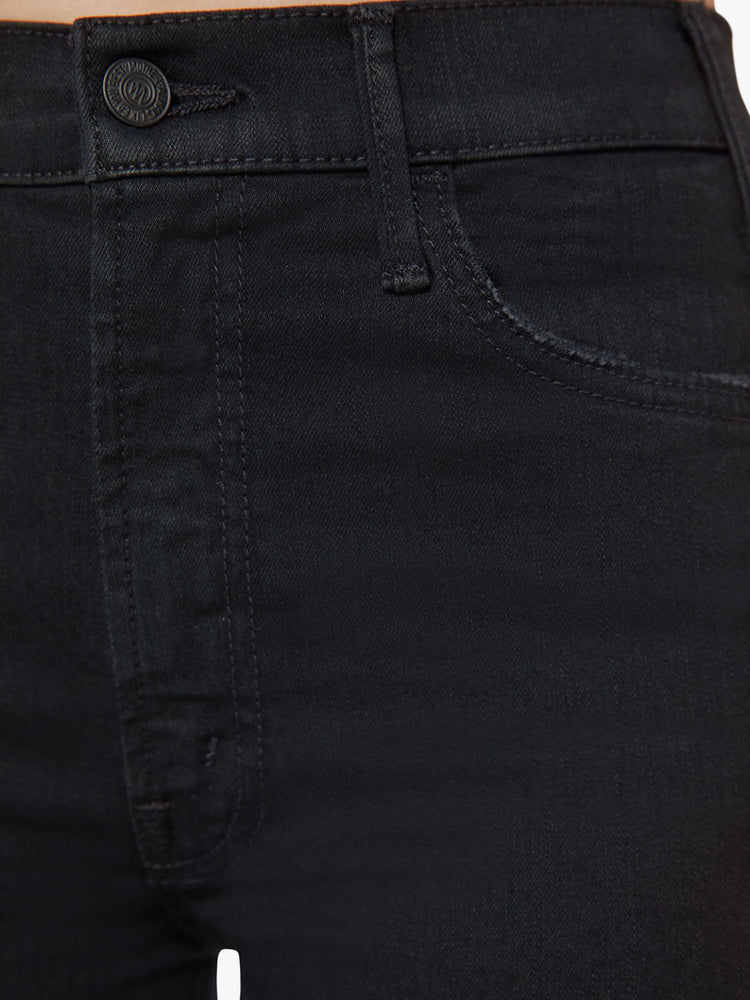 Swatch view of a woman black denim high-rise flare has an ankle-length inseam and a frayed hem.