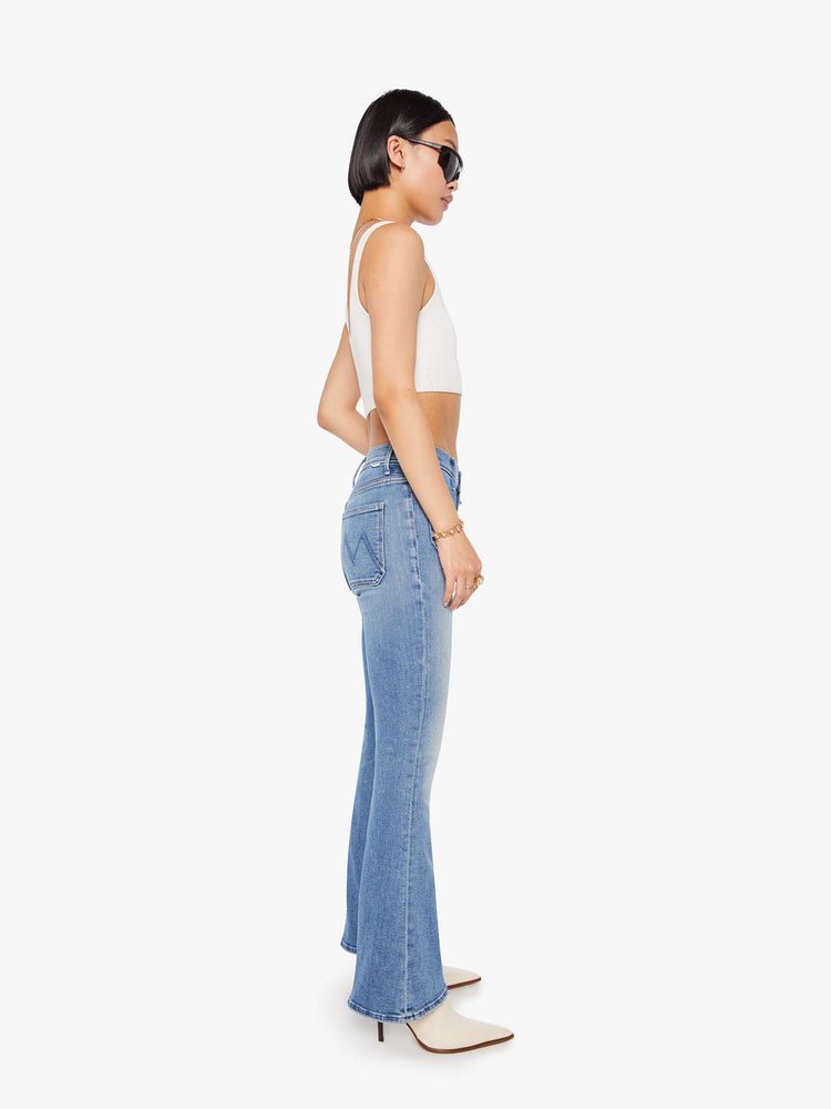 Side view of a petite woman flare has a mid rise, zip fly, patch pockets, a 29-inch inseam and a clean hem.