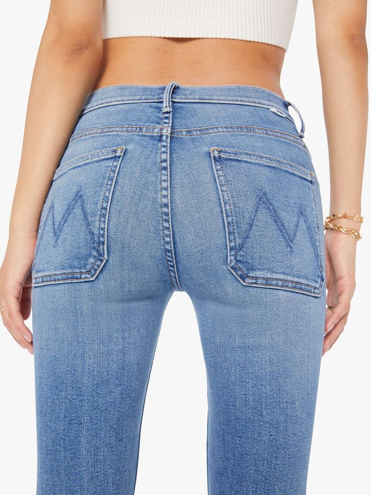 Back close up view of a petite woman flare has a mid rise, zip fly, patch pockets, a 29-inch inseam and a clean hem.