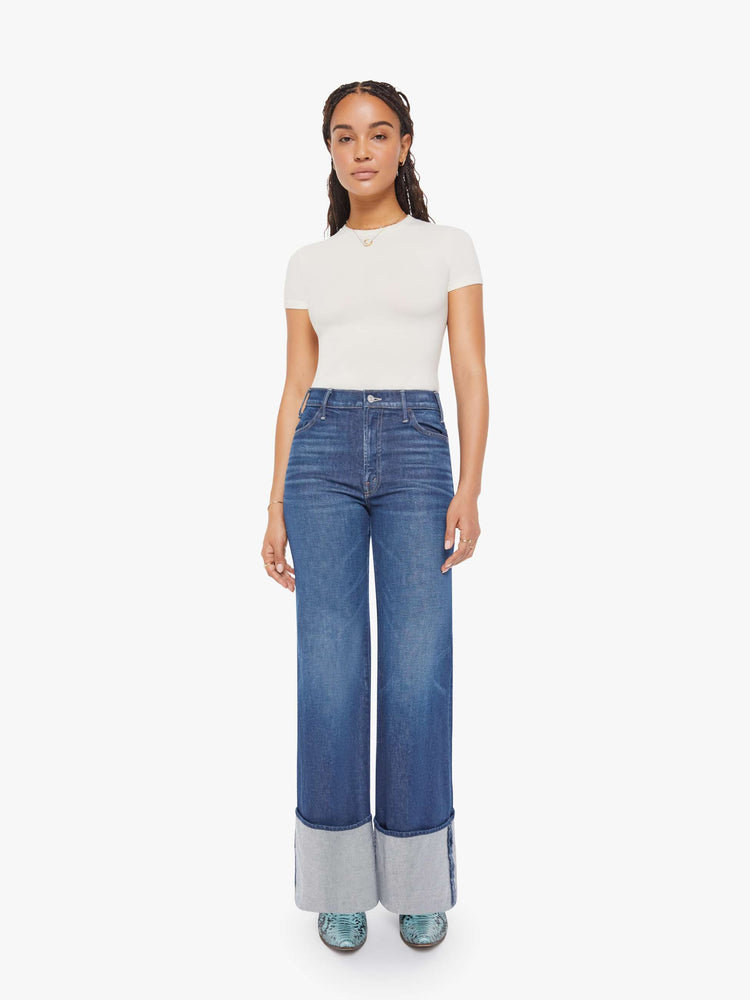 Front view of a petite woman in a dark blue wide leg jeans with a high rise, zip fly and a long 30-inch inseam with an extra-wide cuffed hem.