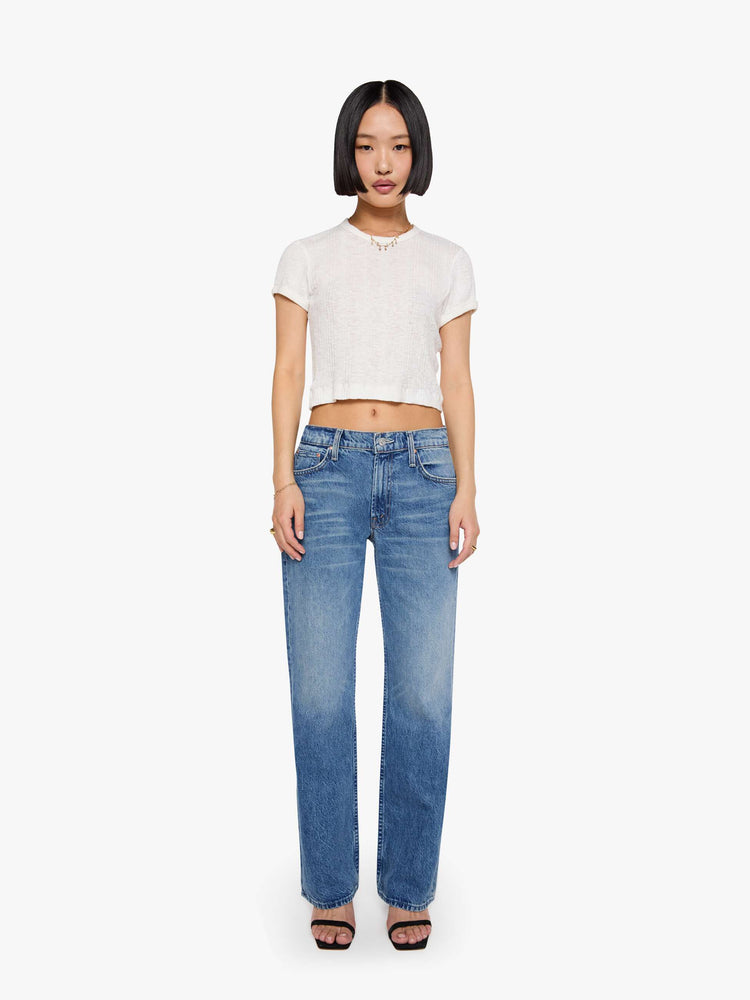 Front view of a petite woman in a  straight leg with a bit of a kick, the jean features a mid rise, full-length inseam and clean hem in med blue wash.