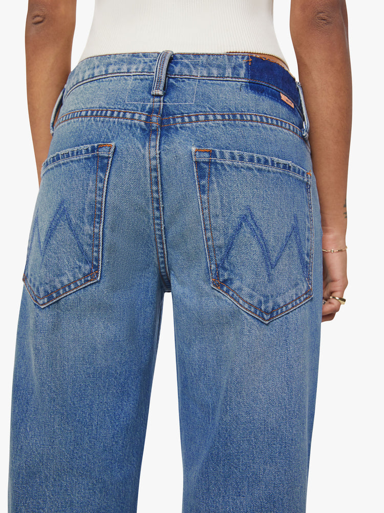 Close up view of a petite woman in a  straight leg with a bit of a kick, the jean features a mid rise, full-length inseam and clean hem in med blue wash.