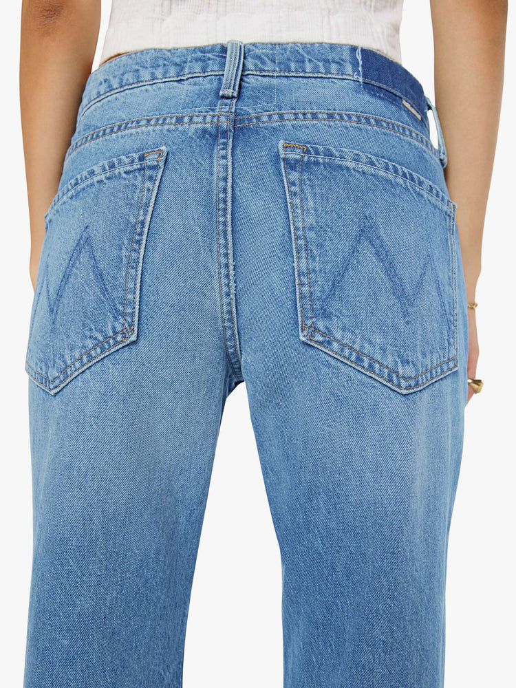Close up view of a petite woman in a  straight leg with a bit of a kick, the jean features a mid rise, full-length inseam and clean hem in med blue wash.