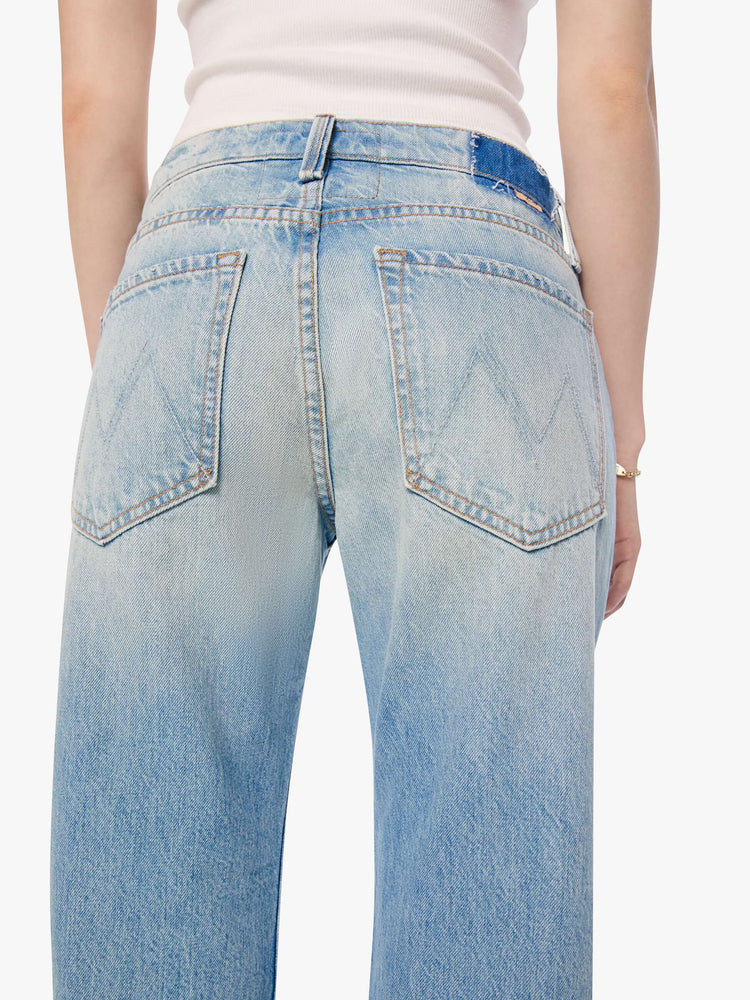 Back close up view of a woman in a sun faded indigo blue straight leg jean with a bit of a kick, the jean features a mid rise, 29-inch inseam, a subtly distressed hem and relaxed fit.