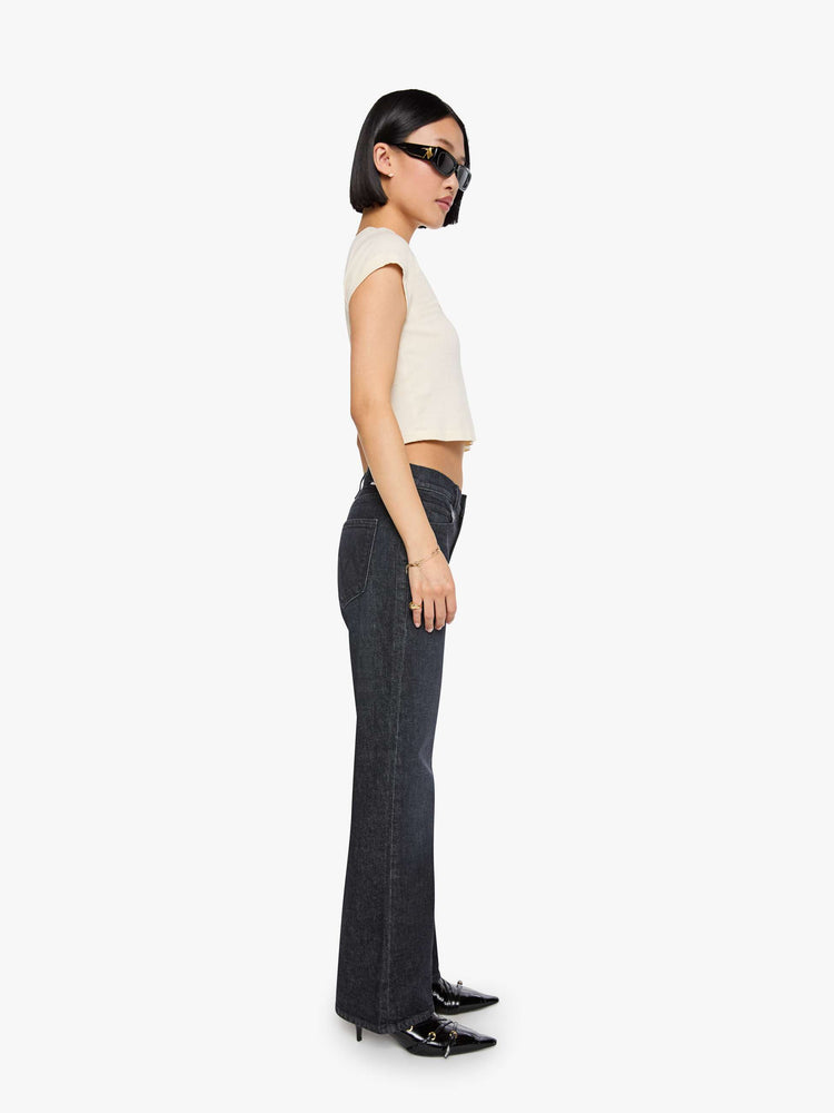 Side view of a woman in a black straight leg with a bit of a kick, the jean features a mid rise, 30-inch inseam, clean hem and relaxed fit. 